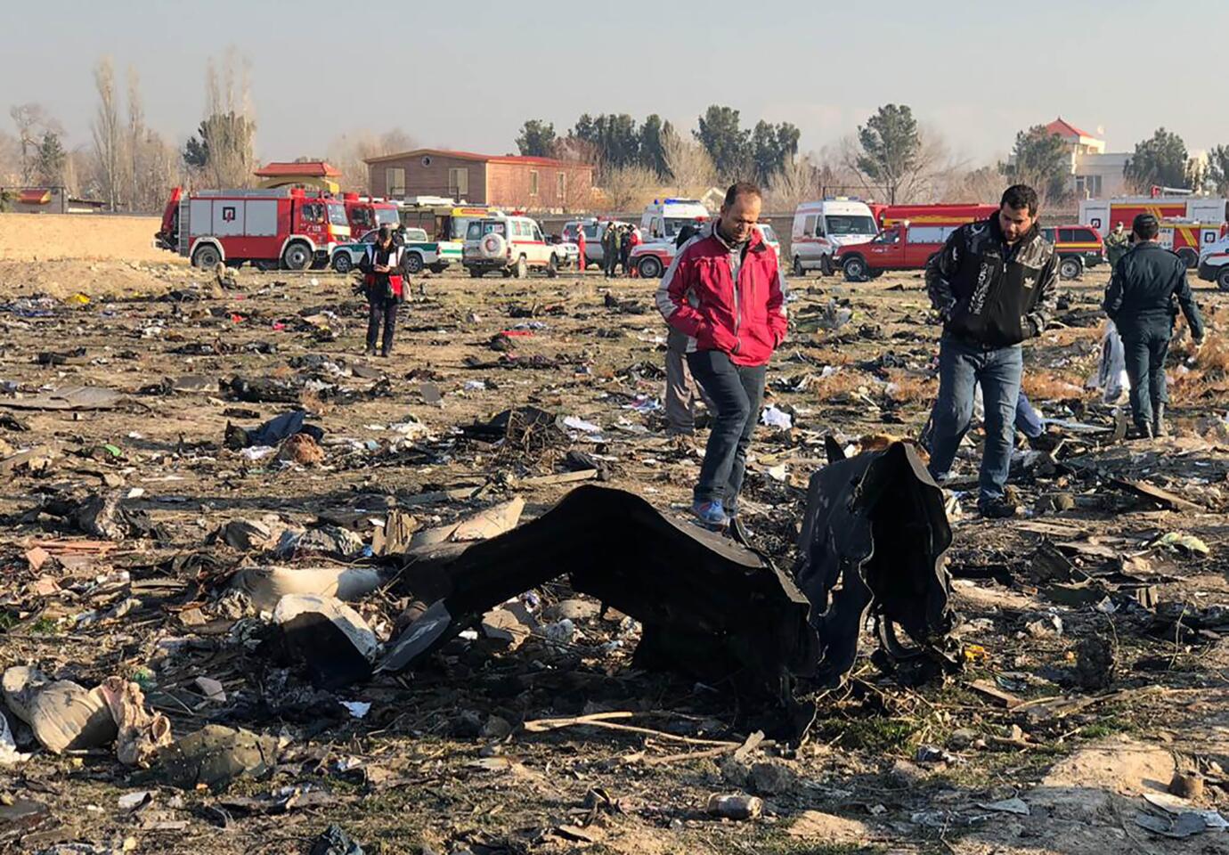 People walk near the plane wreckage on Wednesday. The majority of the 176 passengers were Iranian nationals, Russia's RIA Novosti agency reported, citing Iranian authorities.