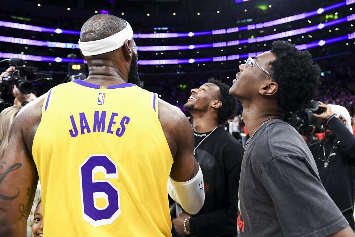 Lakers' LeBron James celebrates with his sons Bryce, right, and Bronny after becoming the all-time NBA scoring leader