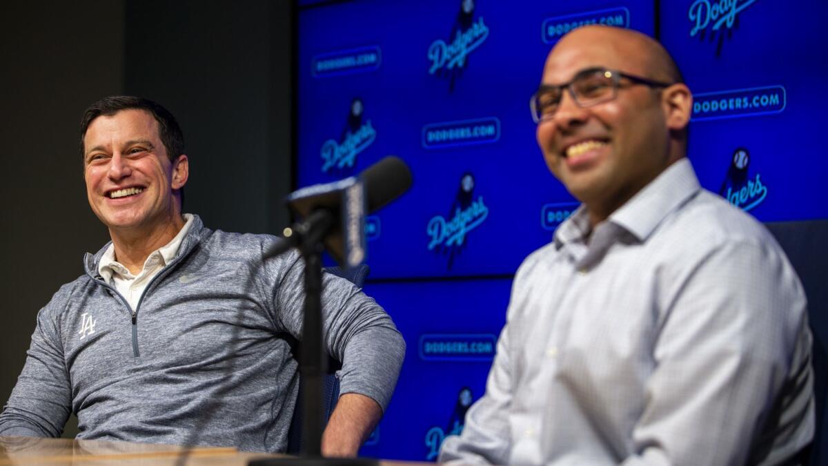 Andrew Friedman, left, and Farhan Zaidi, right, speak at a press conference at Dodger Stadium.