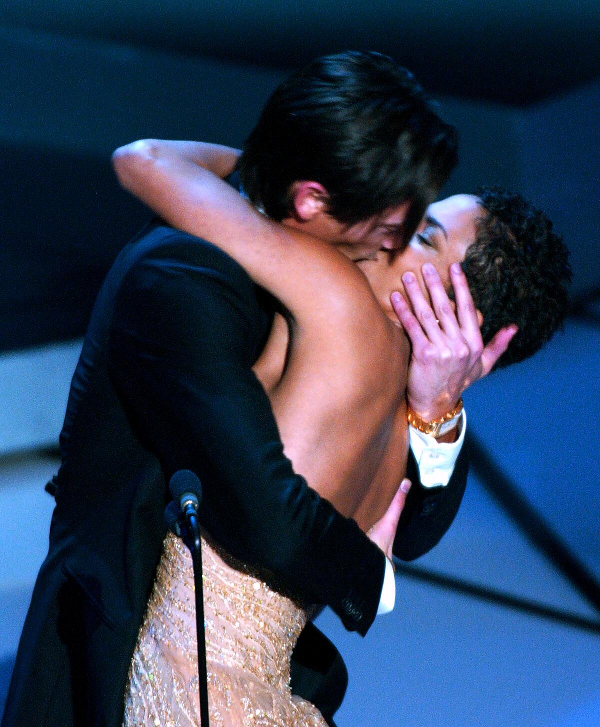A man and woman kissing onstage