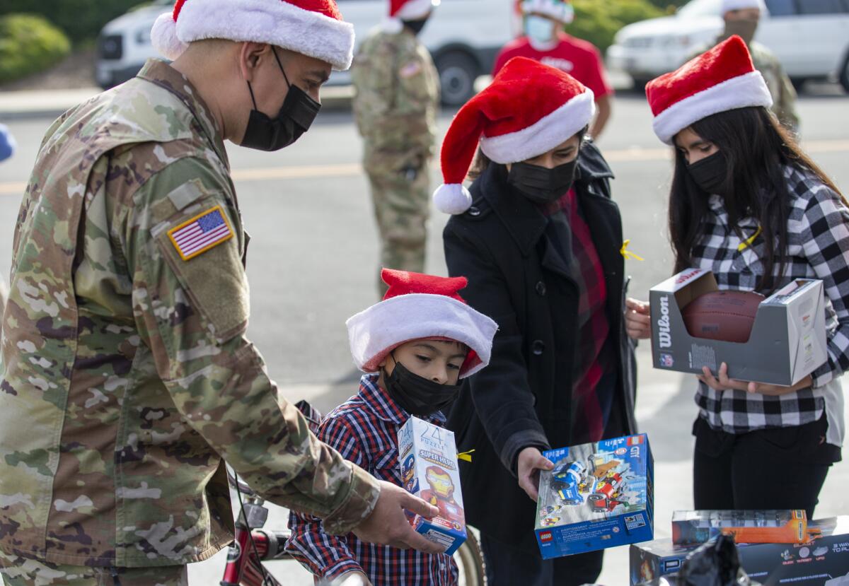 Stf. Sgt. Alonzo Martinez, left, helps his son Abraham pick out a toy.