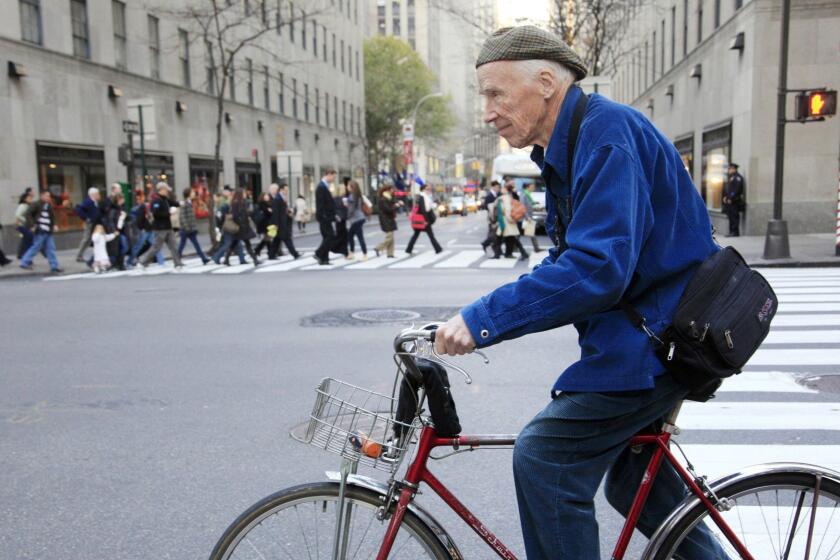 This Nov. 23, 2010 photo shows New York Times photographer Bill Cunningham bicycling to work in New York. Cunningham, a longtime fashion photographer for The New York Times known for taking pictures of everyday people on the streets in New York died on Saturday, June 25, 2016, after suffering a stroke in New York. He was 87. (AP Photo/Mark Lennihan)