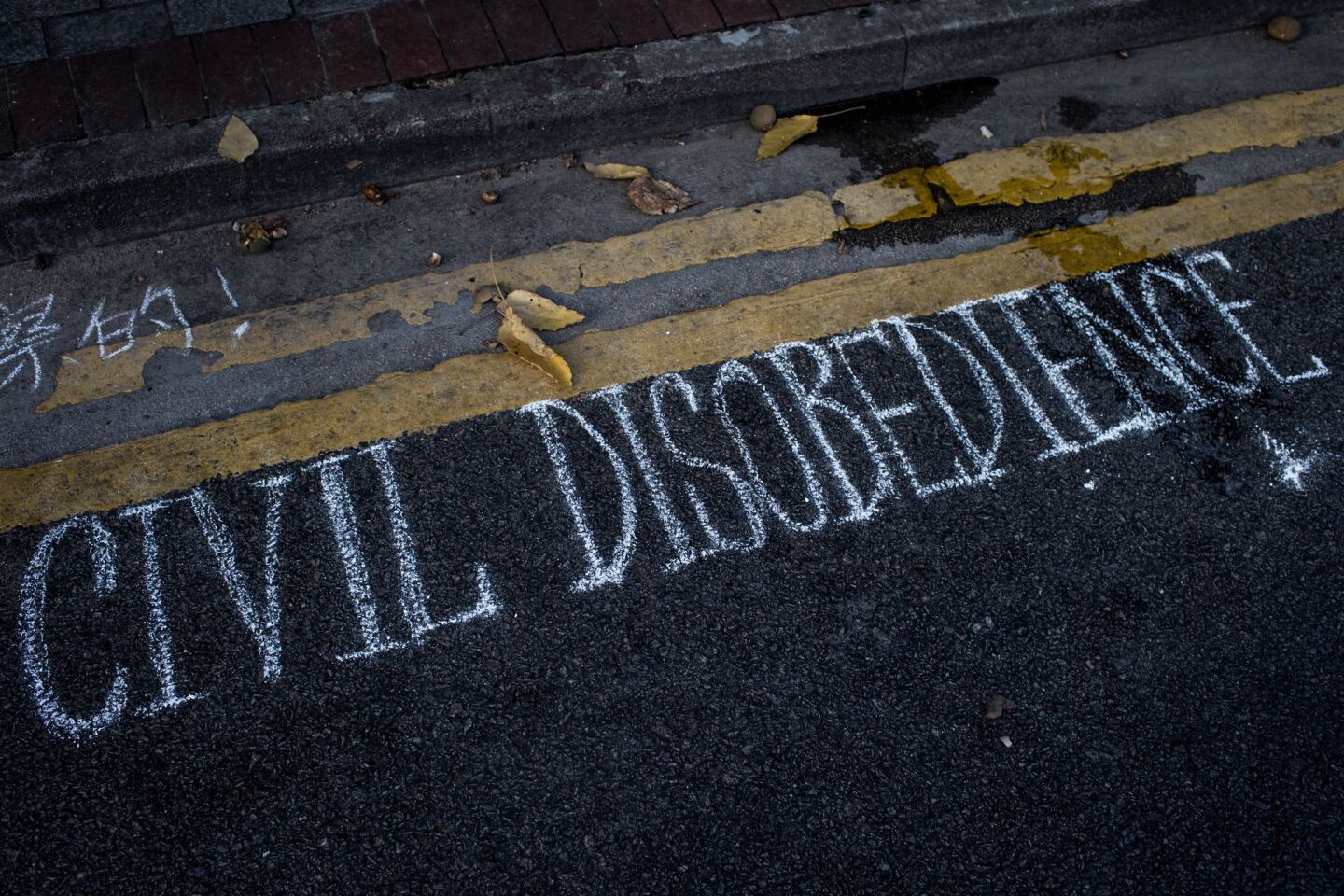 A Civil Disobedience sign written on the street in chalk in Hong Kong, where thousands of pro-democracy supporters continue to occupy the streets surrounding Hong Kong's financial district.