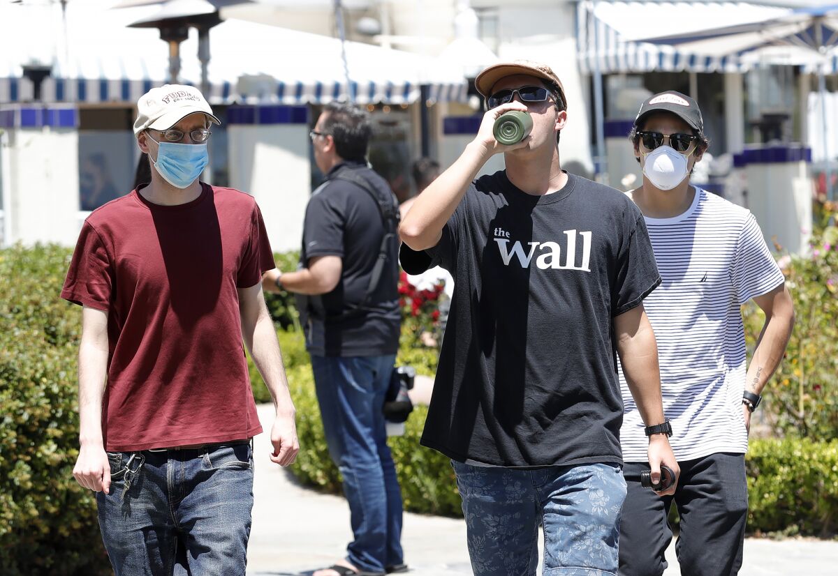 Teenagers walk near Heisler Park in Laguna Beach on Thursday.