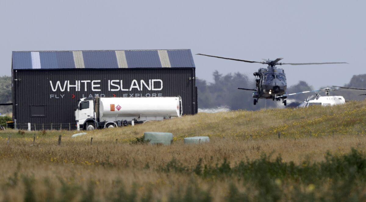 A navy helicopter returns to Whakatane, New Zealand, following a recovery operation on White Island on Friday. Police said another recovery operation was planned for two bodies still missing.
