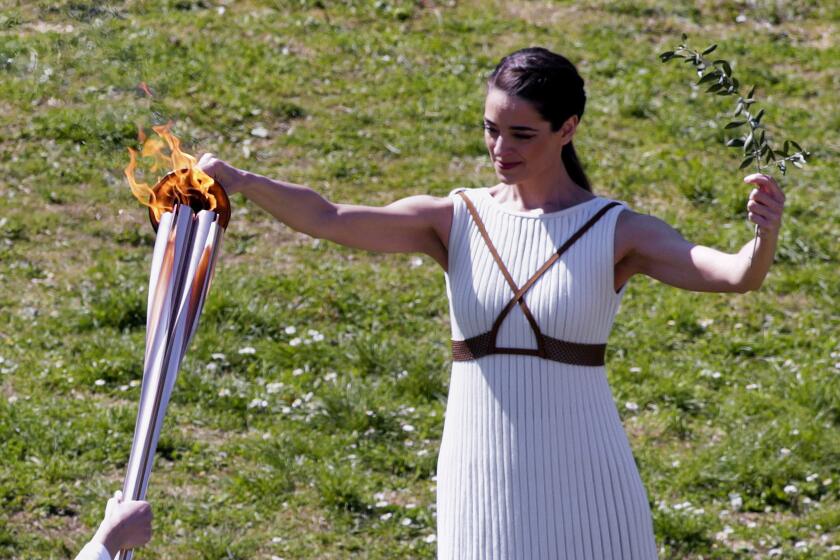 ATHENS, GREECE - MARCH 12: Greek actress Xanthi Georgiou, playing the role of High Priestess passes the flame to the first torchbearer, during the opening of the Olympic flame torch relay for the Tokyo 2020 Summer Olympics on March 12, 2020 in ancient Olympia. (Photo by Milos Bicanski/Getty Images)