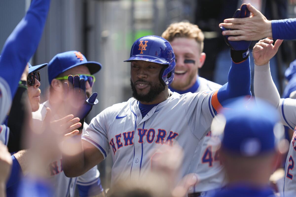 New York's Starling Marte celebrates in the dugout after hitting a three-run home run in the sixth inning Saturday.