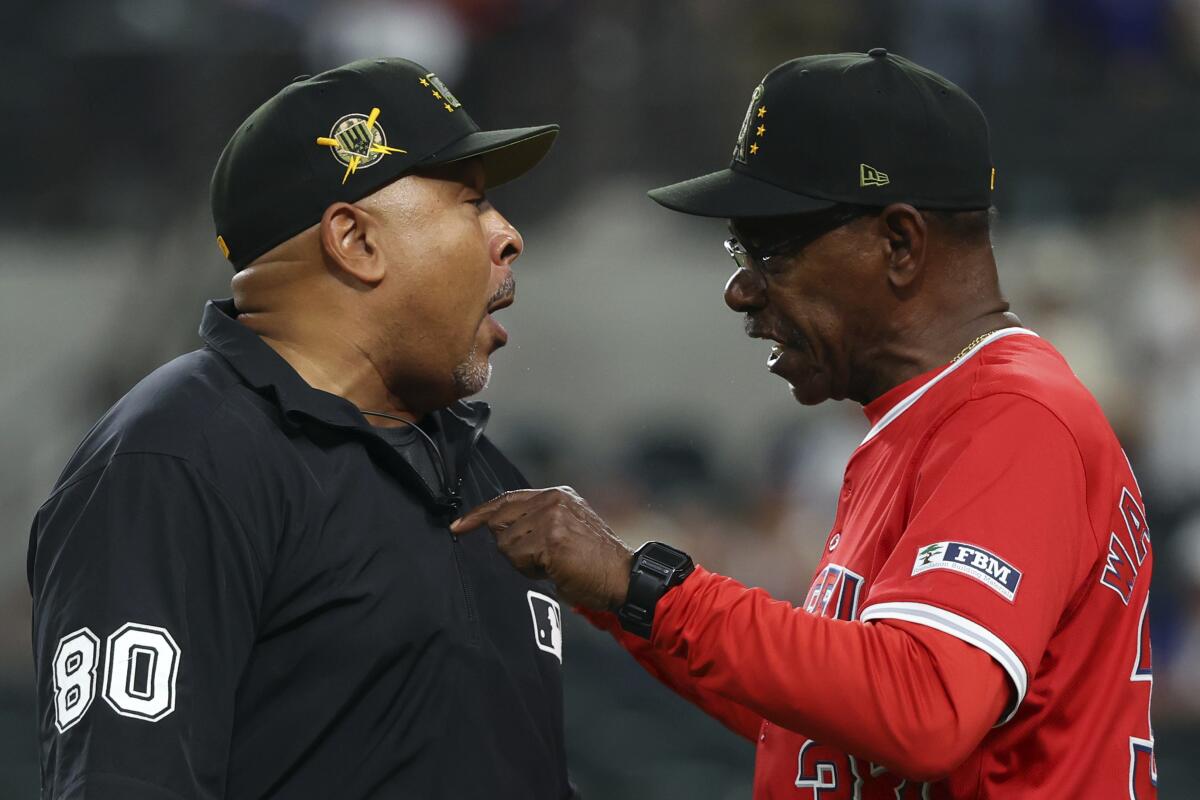 O árbitro da terceira base, Adrian Johnson, e o técnico dos Angels, Ron Washington, discutem.