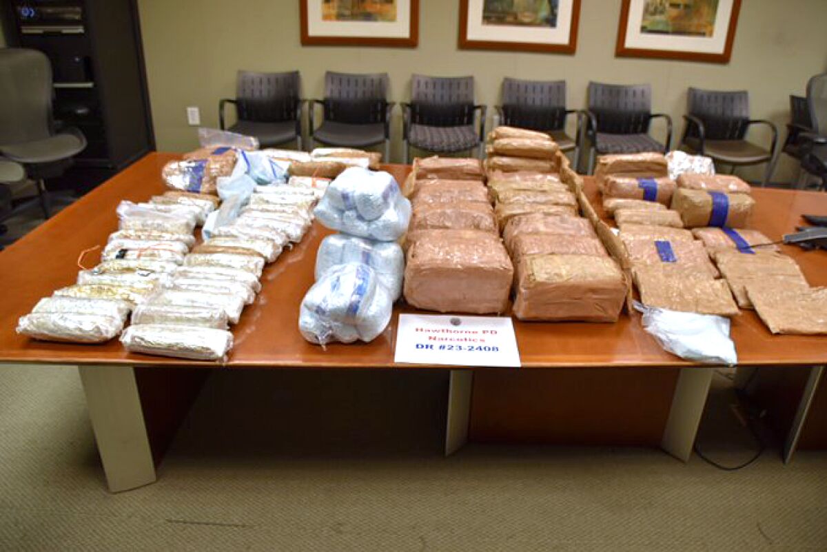 Packages wrapped in brown and white plastic laid out across a large, conference room-style table.