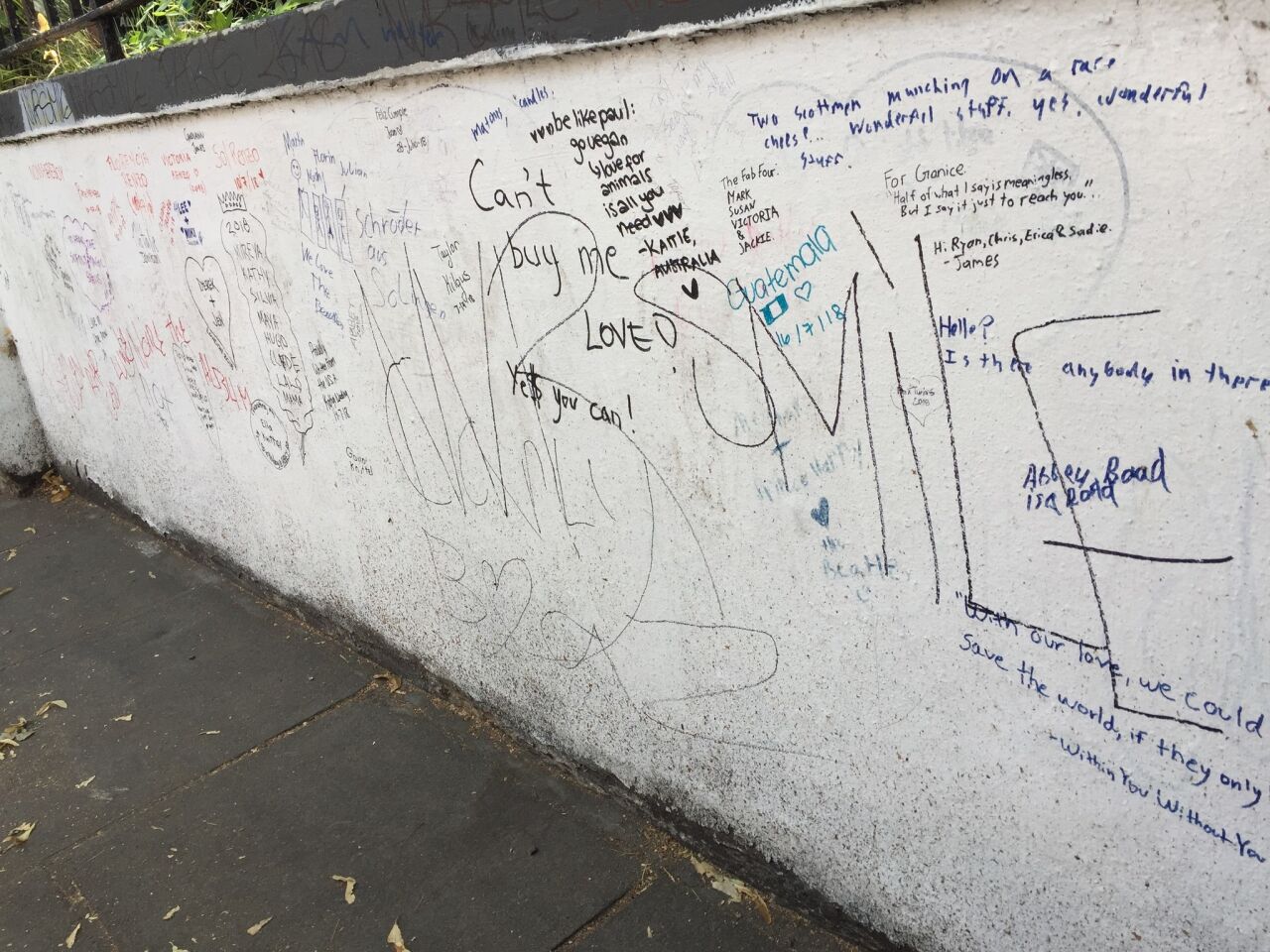 The exterior wall of Abbey Road Studios where fans are invited to write messages or sign their names.