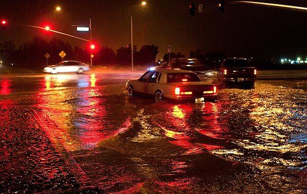 Traffic lights are reflected in floodwaters on Indiana Avenue at the Ramona Expressway during heavy rains.
