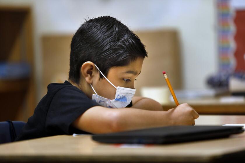 Los Angeles, California-June 23, 2021-Third grader David Cortez wears his mask during class at Hooper Avenue School on June 23, 2021. Student wears his mask during third grade summer school at Hooper Avenue School on June 23, 2021. (Carolyn Cole / Los Angeles Times)