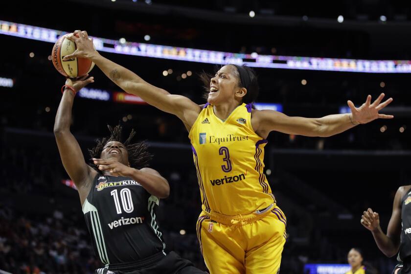 FILE - Los Angeles Sparks' Candace Parker, right, blocks a shot by New York Liberty's Epiphanny Prince during the second half of a WNBA basketball game, Aug. 4, 2017, in Los Angeles. While the fight for gender equity continues around the sports world, 26 years after it was launched the WNBA is one of the longest running professional women's sports league. (AP Photo/Jae C. Hong, File)