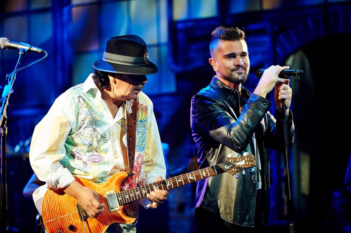 Carlos Santana, left, and Juanes perform during the Univision upfront presentation in New York.