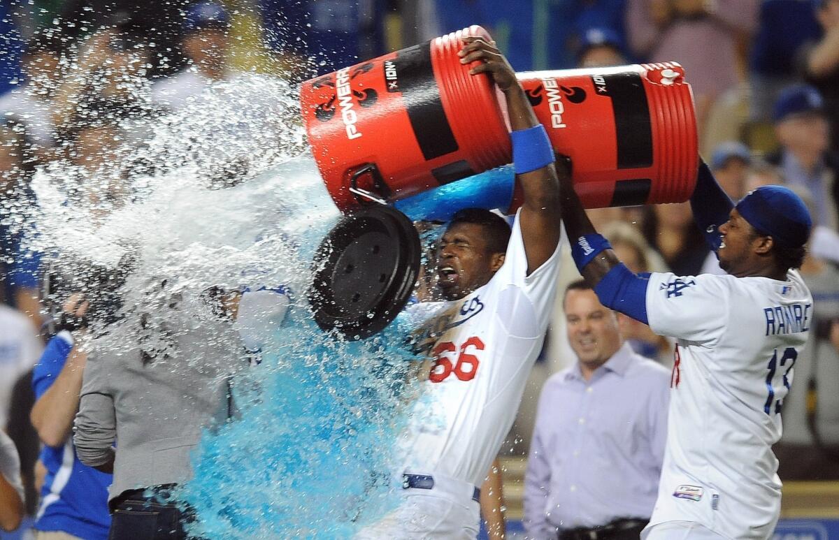 Dodgers teammates Yasiel Puig, center, and Hanley Ramirez give Scott Van Slyke a watercooler shower after Van Slyke's pinch-hit, two-run home run in the 11th inning of the Dodgers' 5-3 win over the Arizona Diamondbacks on Tuesday.