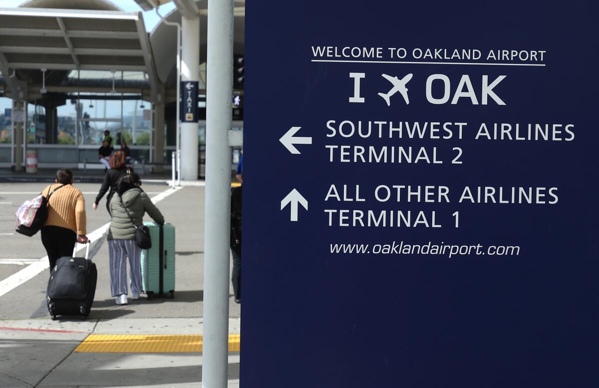 Travelers walk toward Terminal 1 at Oakland International Airport.