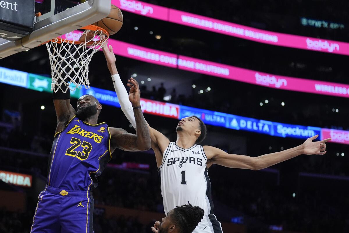 Lakers star LeBron James battles San Antonio Spurs center Victor Wembanyama for a rebound.