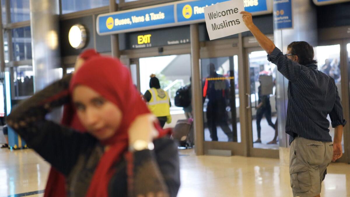 A protester at LAX holds a sign welcoming Muslims to the United States on Thursday.
