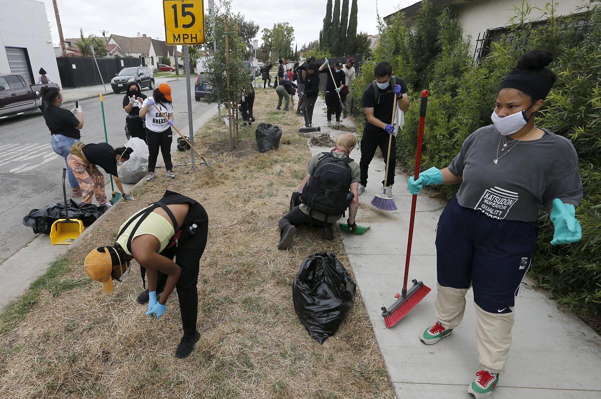 Volunteers pull weeds along in South Los Angeles during community cleanup on Friday, June 5, 2020.