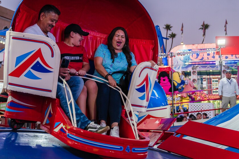 People ride the Tilt-A-Whirl at the San Diego County Fair