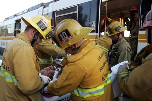 Los Angeles Fire Department paramedics tend to an injured passenger of a Metro Blue Line train after it collided with a bus in downtown Los Angeles. The train was headed for Long Beach. There were no passengers on the bus.