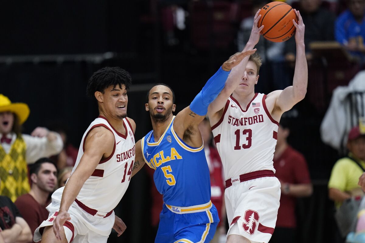 Stanford guard Michael Jones looks to pass as UCLA guard Amari Bailey defends against forward Spencer Jones.