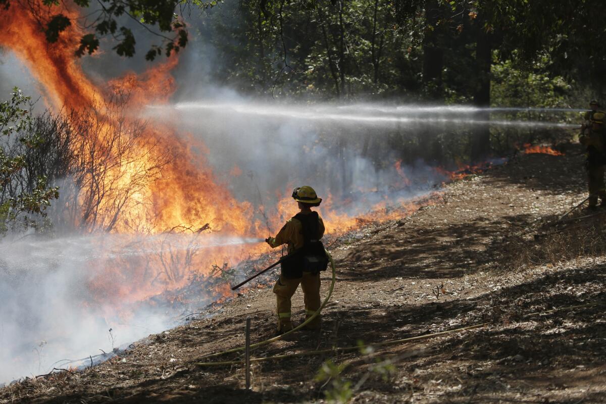 Firefighters battle the King fire in the Eldorado National Forest earlier this month. The state has exhausted its budget for battling wildfires.