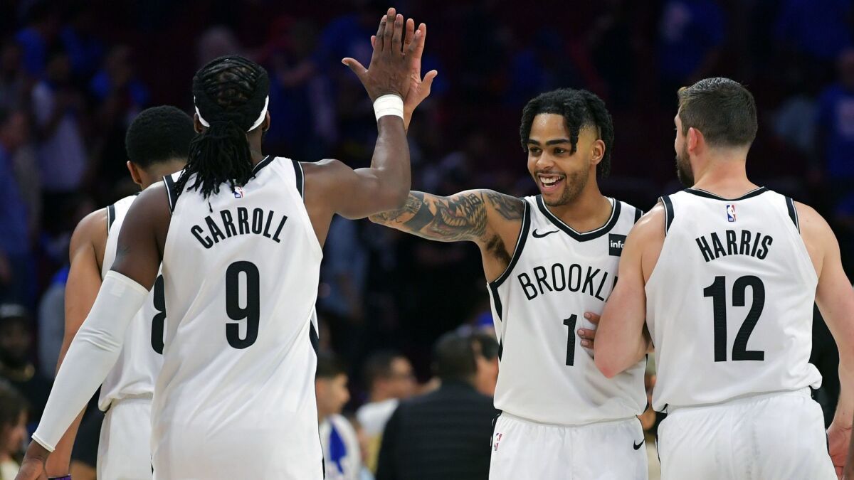 D'Angelo Russell (1) of the Brooklyn Nets celebrates with teammates DeMarre Carroll (9) and Joe Harris (12) after beating the Philadelphia 76ers 111-102 during Game 1 of the first round of the NBA Playoff at Wells Fargo Center in Philadelphia.