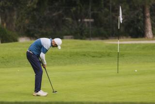 Los Angeles, CA - March 15: A golfer putts his ball into a hole at the Wilson Golf Course on Friday, March 15, 2024 in Los Angeles, CA. (Carlin Stiehl / For The Los Angeles Times)