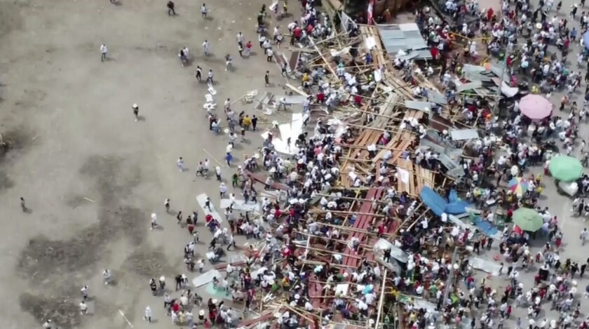 En esta imagen tomada de un video, los espectadores se aglomeran alrededor de las gradas de madera que se derrumbaron 