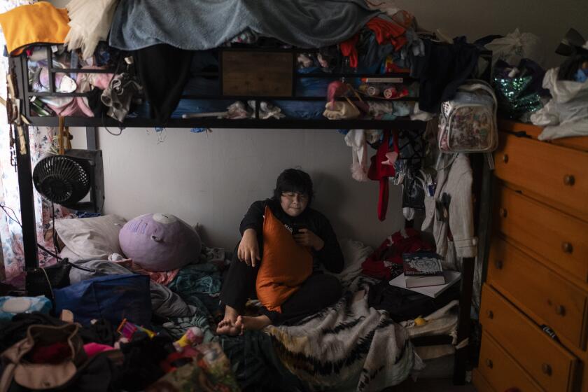 Deneffy Sánchez, de 15 años, descansa en una cama que comparte con su madre y hermanita