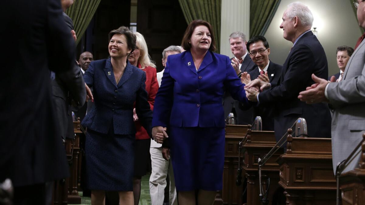 Toni Atkins, D-San Diego walks hand in hand with her spouse, Jennifer LeSar, to the rostrum of the Assembly to take the oath of office as Assembly speaker on May 12, 2014