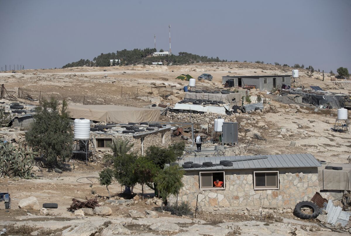 FILE - The Israeli settlement of Ma'on, in the background and overlooks the the West Bank Palestinian Bedouin village of al-Mufagara, near Hebron, Sept. 30, 2021. On Sunday, Nov. 1, 2021, Israel authorized some 1,300 Palestinian homes in the occupied West Bank days after advancing plans to build more than 3,000 housing units for Jewish settlers. The Israeli government said it is adopting a moderate approach with the aim of minimizing friction with the U.S. — which is opposed to settlements — and tensions within its ruling coalition, which includes parties from across the political spectrum. (AP Photo/Nasser Nasser, File)