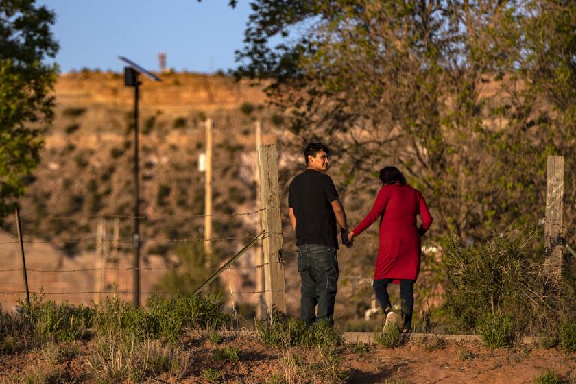 WINDOW ROCK, AZ - MAY 24: A young couple take an evening stroll on the Navajo Reservation on Sunday, May 24, 2020 in Window, AZ. Lockdown curfews are being enforced over the weekends in an effort to slow the coronavirus' spread. (Brian van der Brug / Los Angeles Times)