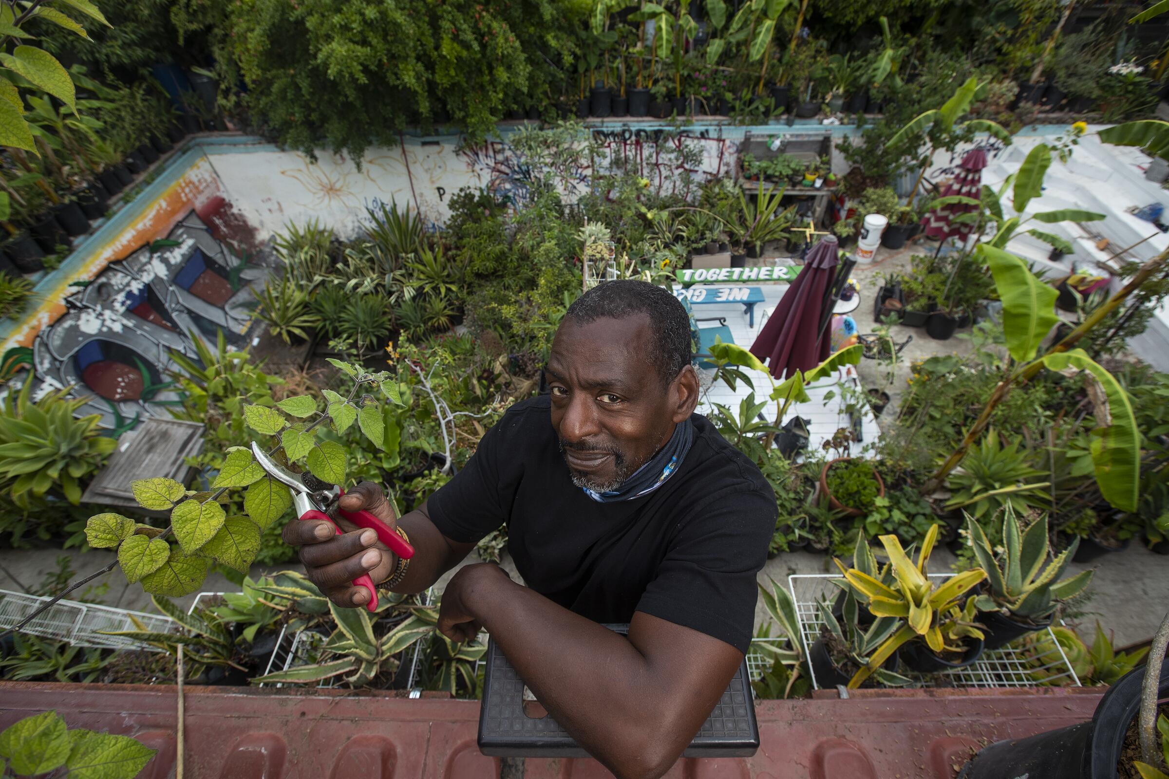 Ron Finley, the Gangsta Gardener, poses in the backyard garden of his West Adams home.