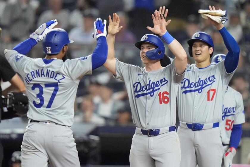 Teoscar Hernández celebrates with Dodgers teammates Will Smith and Shohei Ohtani after hitting a grand slam.
