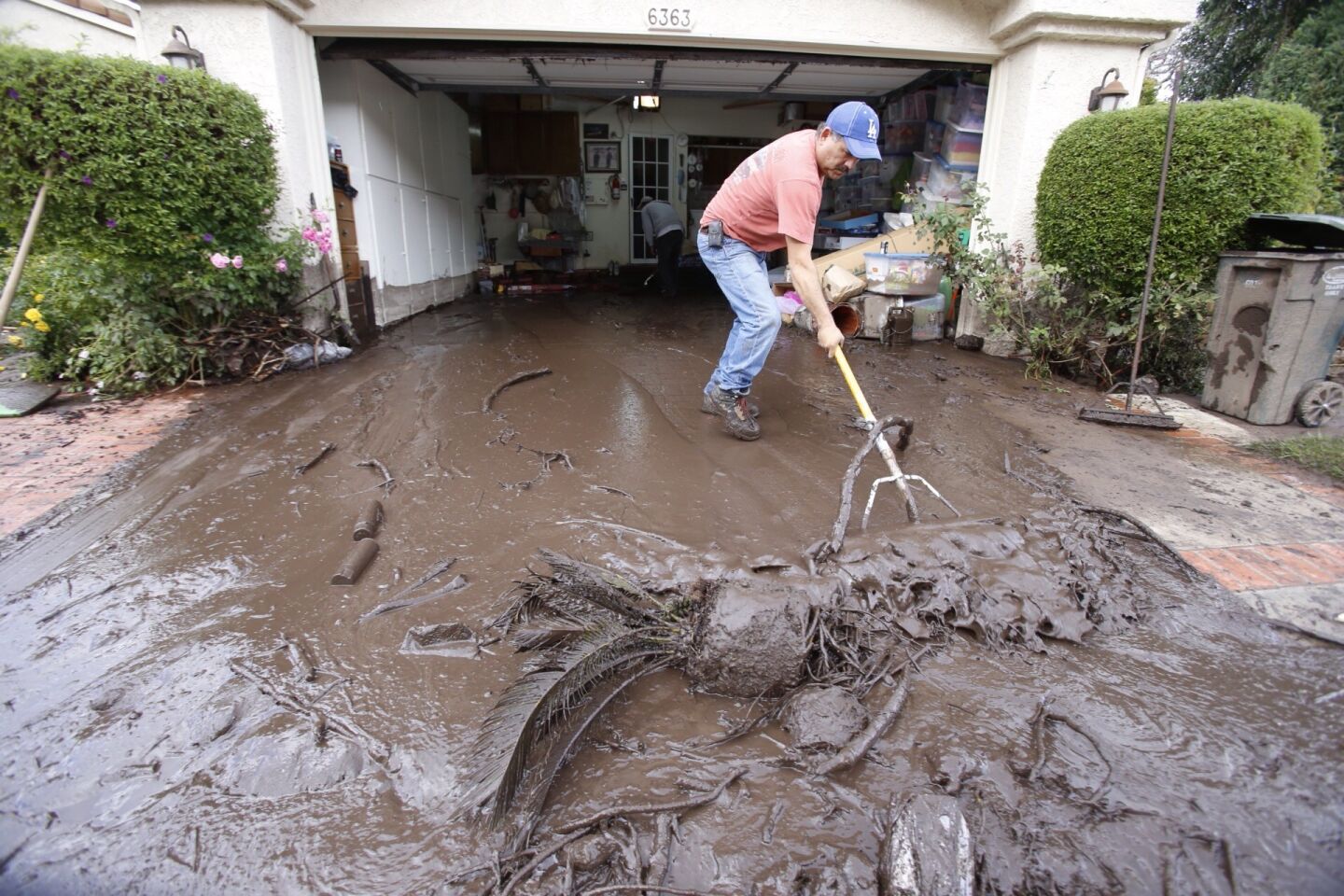 Salvador Medina clears mud from a garage in Camarillo Springs.