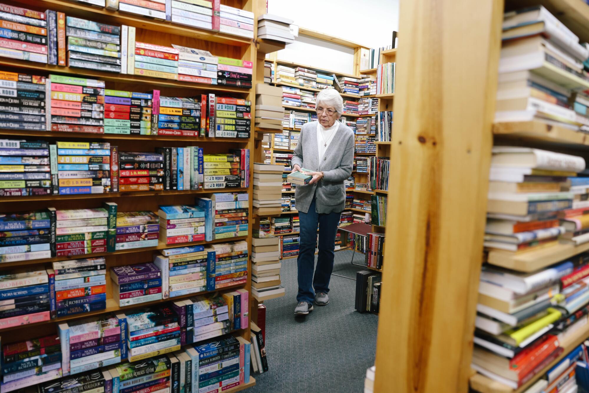 A woman walks through a bookstore. 