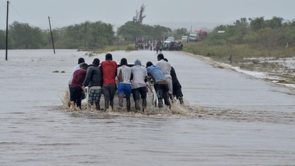 Residents push a car through the floodwater in Mazive, southern Mozambique. Heavy rains from a powerful cyclone lashed northern Mozambique, just weeks after the country suffered one of the worst storms in its history.