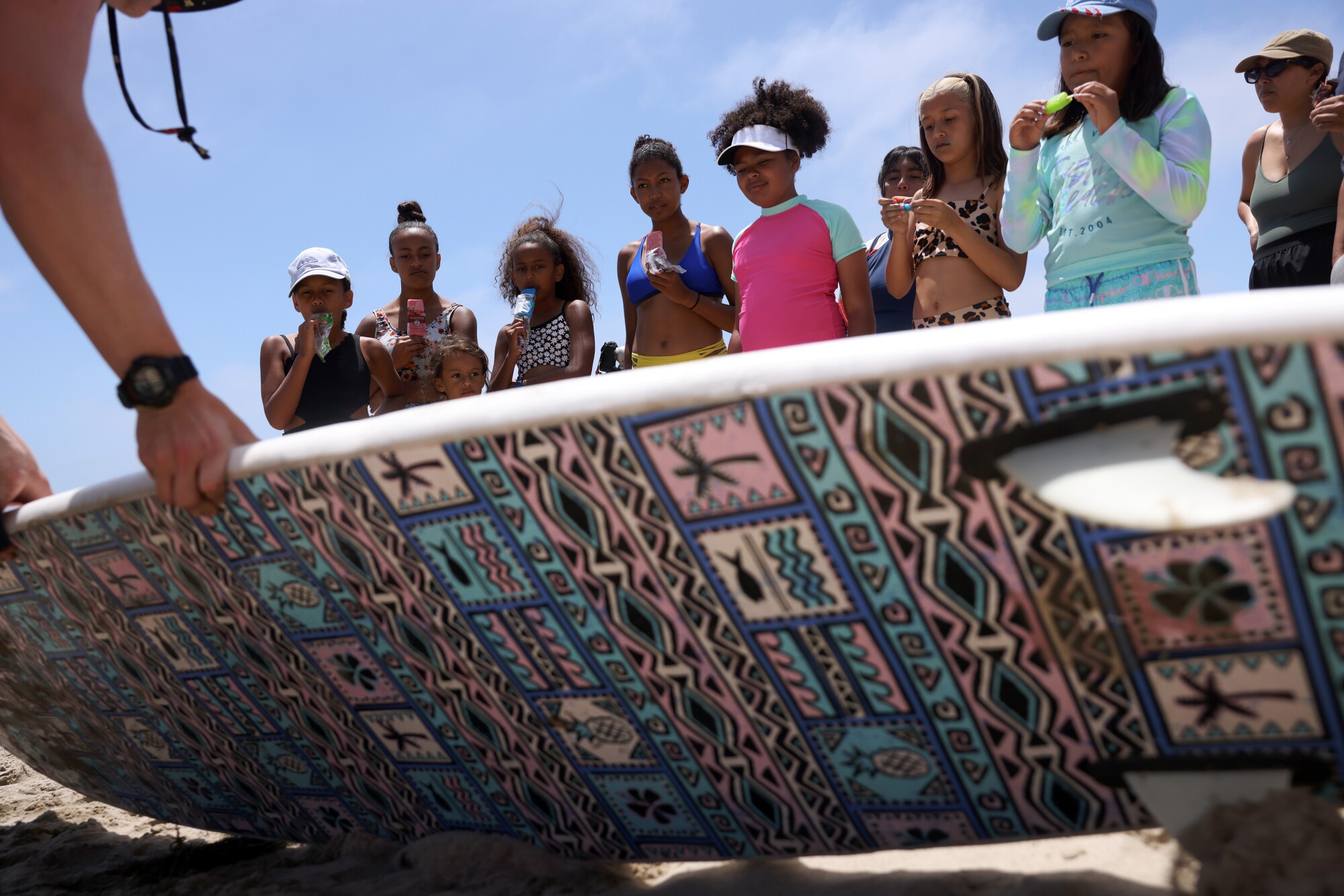 Les participants à un événement Los Courage Camp regardent un instructeur donner des conseils sur la façon de surfer à First Point à Malibu.