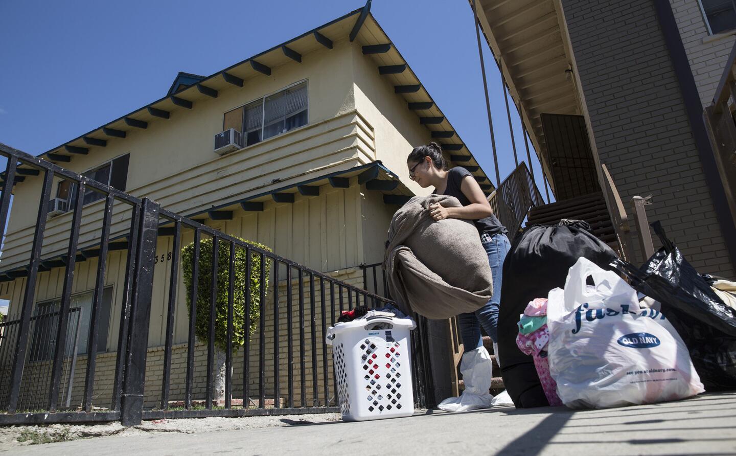52nd Street resident Fatima Hernandez retrieves belongings from her home adjacent to a metal recycling facility that burned in Maywood last week.