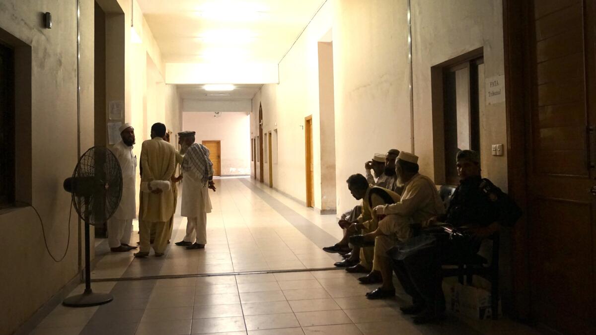 Pakistani tribesmen talk as they wait to enter the FATA Tribunal for a hearing. FATA stands for Federally Administered Tribal Areas.