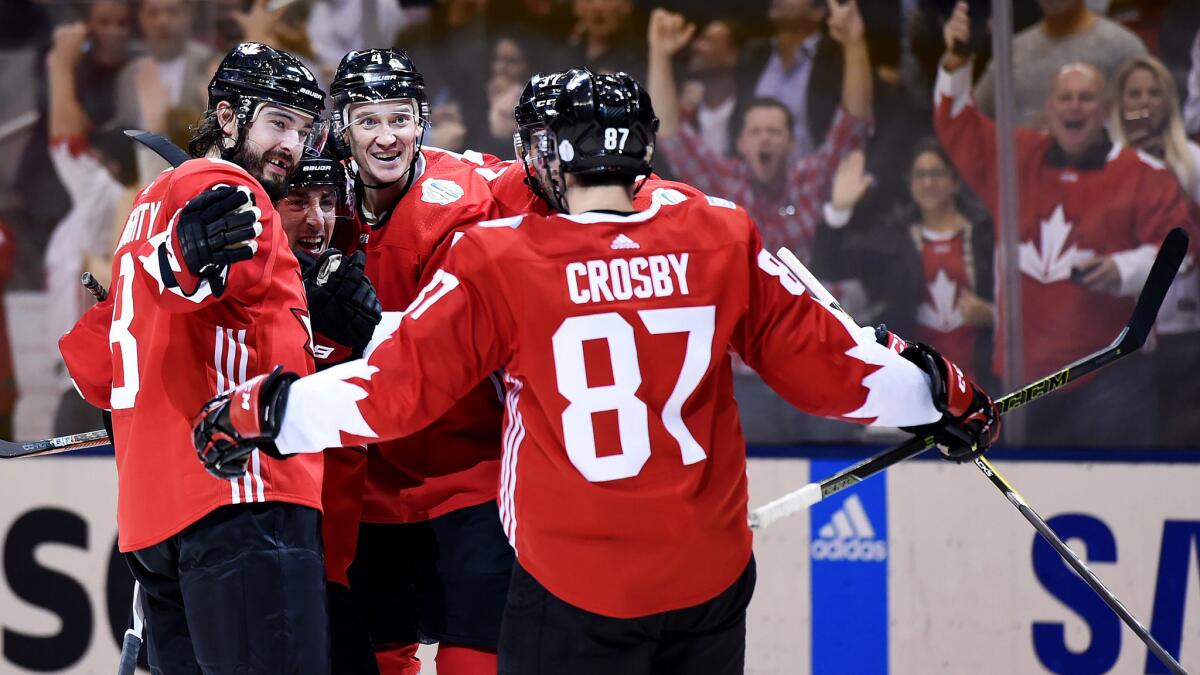 Team Canada defenseman Drew Doughty, left, celebrates with Brad Marchand, second from left, and other teammates after Marchand scored a goal against Team Russia during the third period Saturday.