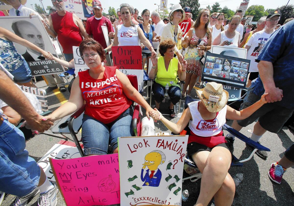 Protesters pray before a rally outside a Market Basket store in Tewksbury, Mass., on Aug. 5.