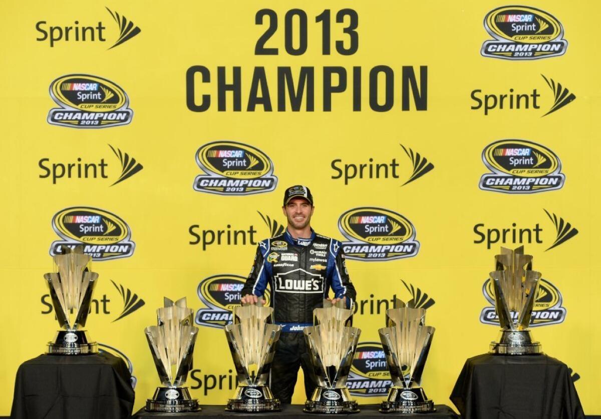 Jimmie Johnson poses with his six Sprint Cup championship trophies.