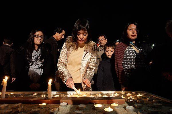 Community members light candles for the victims of the earthquake and tsunami during a ceremony at the Japanese American Community & Cultural Center in Los Angeles' Little Tokyo. See full story