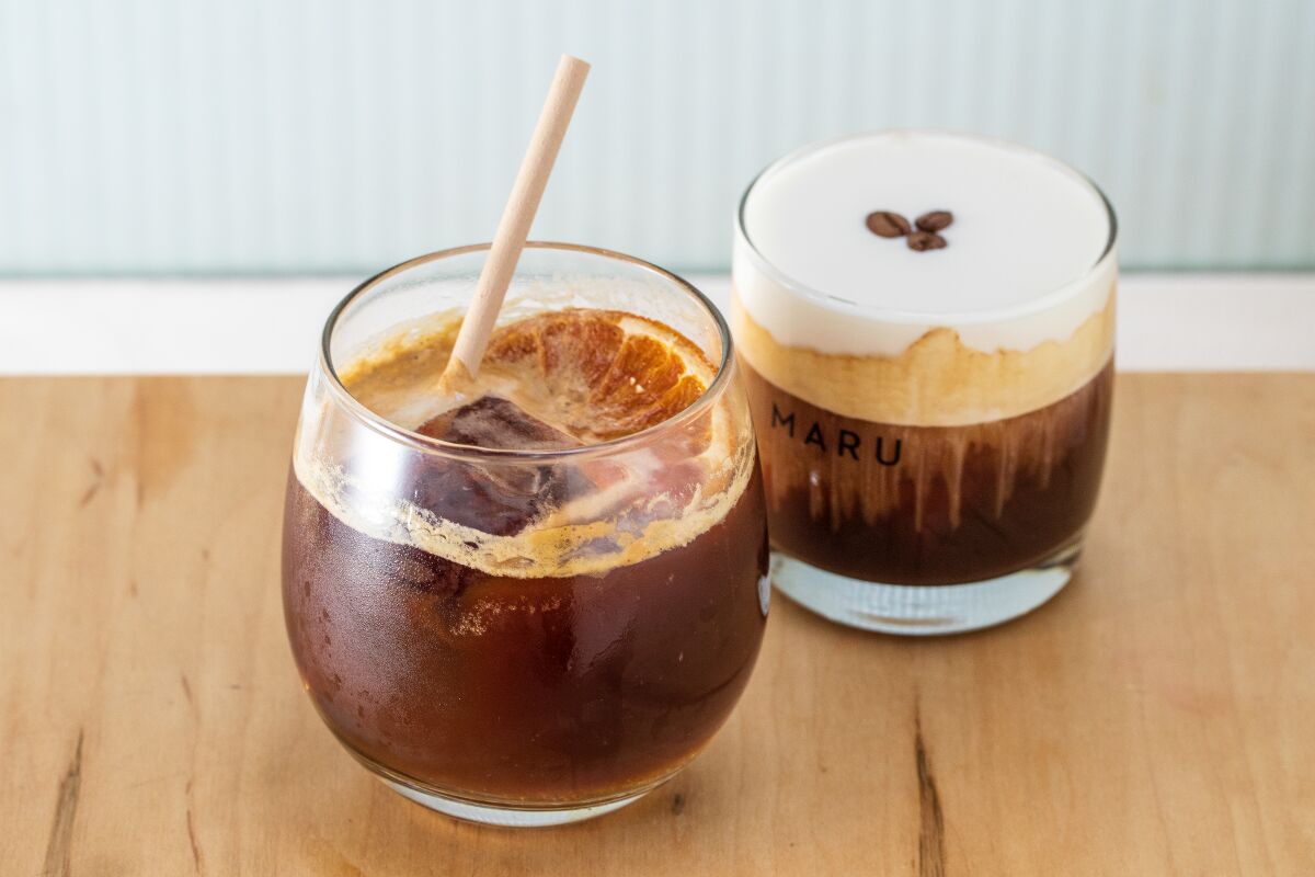 Two clear glasses hold coffee drinks, one with a creamy top, from Maru