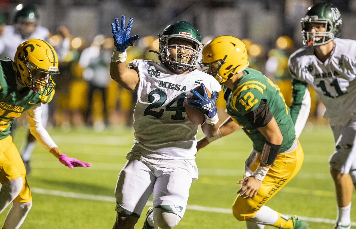 Costa Mesa's Kobe Lemari raises a hand in celebration as he crosses the goal line against Saddleback.