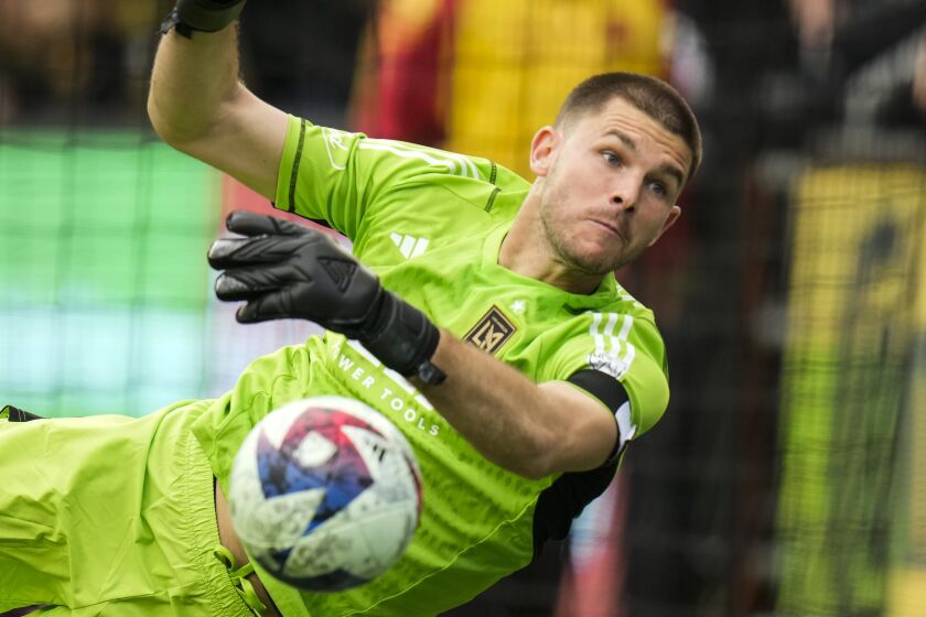 Los Angeles FC goalkeeper John McCarthy dives to make a save during the first half of an MLS soccer match.