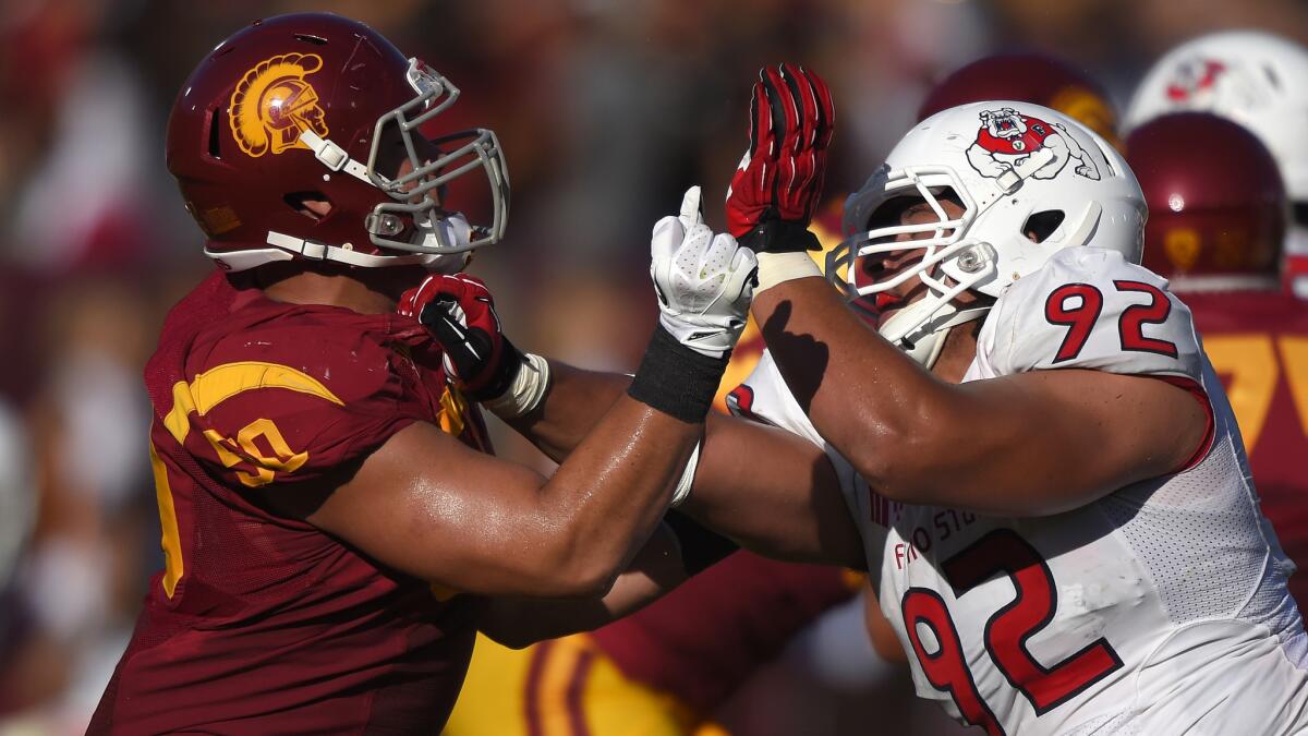 USC offensive lineman Toa Lobendahn, left, battles Fresno State defensive lineman Tyeler Davison during the Trojans' season opener Aug. 30.